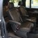The middle row of a van with two leater seats and a console between them
